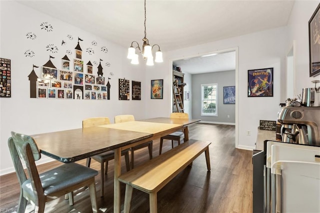 dining area with dark wood-type flooring, a chandelier, and baseboards