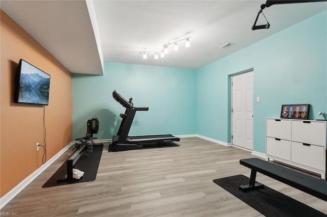 workout room featuring wood finished floors and baseboards