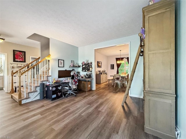 living room with wood finished floors, stairs, and a textured ceiling