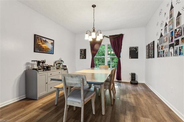 dining area featuring a chandelier, dark wood-style flooring, and baseboards