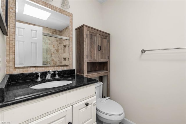 bathroom featuring toilet, a shower with shower door, vanity, and baseboards