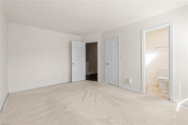 unfurnished bedroom with carpet, connected bathroom, and baseboards