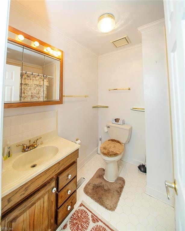 full bathroom with toilet, baseboards, visible vents, vanity, and crown molding