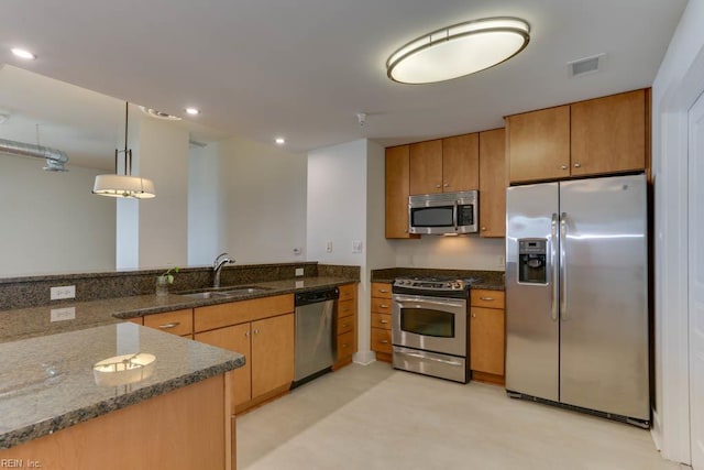 kitchen featuring brown cabinets, stainless steel appliances, visible vents, and a sink