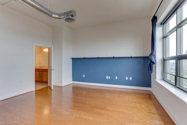 empty room with baseboards and wood finished floors
