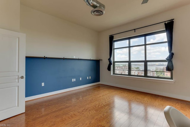 unfurnished room with baseboards and wood finished floors