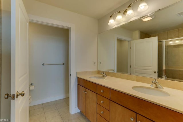full bathroom featuring a sink, tile patterned floors, an enclosed shower, and double vanity