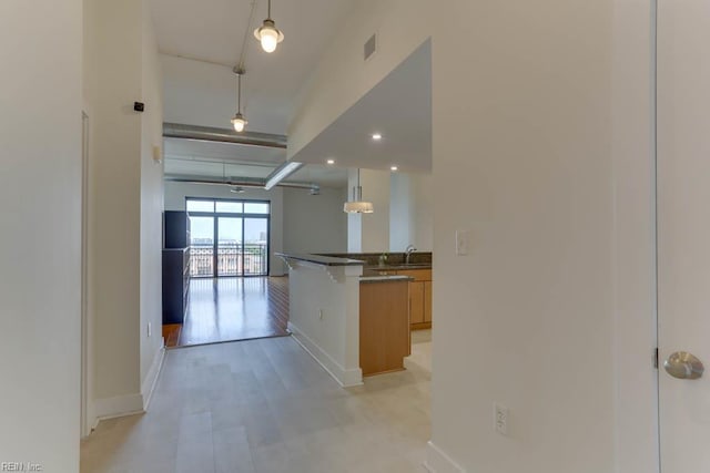 corridor featuring a sink, baseboards, and visible vents