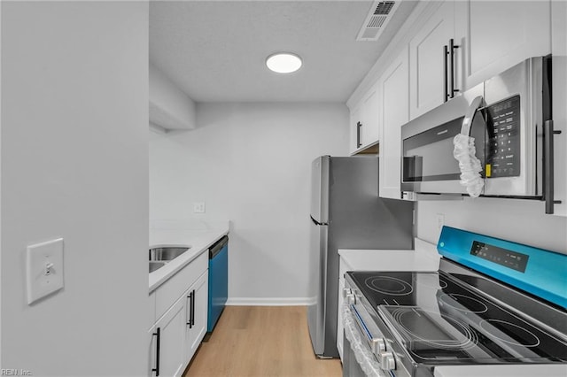5117 Walkers Grant Ln Unit A, Virginia Beach, VA 23455 - kitchen featuring stainless steel appliances, light wood-type flooring, white cabinetry, and visible vents