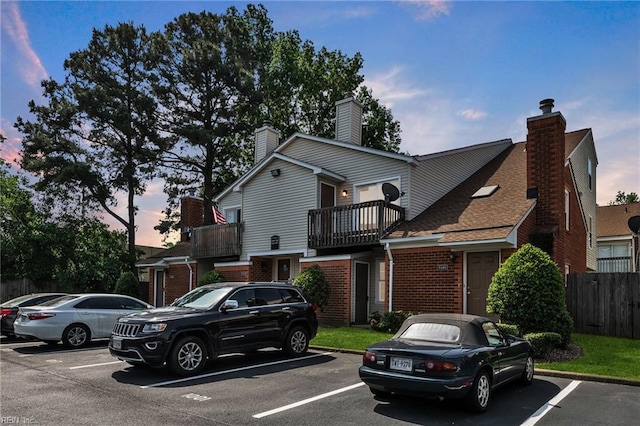 5117 Walkers Grant Ln Unit A, Virginia Beach, VA 23455 - view of front of home featuring brick siding, uncovered parking, a balcony, and a chimney