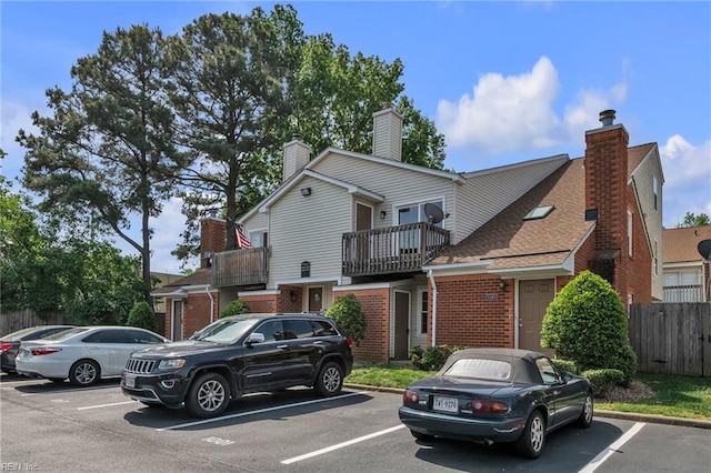 5117 Walkers Grant Ln Unit A, Virginia Beach, VA 23455 - view of front of home featuring brick siding, fence, uncovered parking, and a balcony