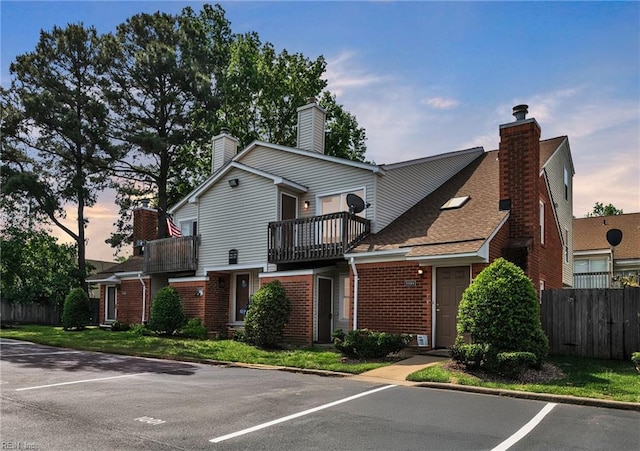 5117 Walkers Grant Ln Unit A, Virginia Beach, VA 23455 - view of front of house with fence, a chimney, brick siding, and a balcony