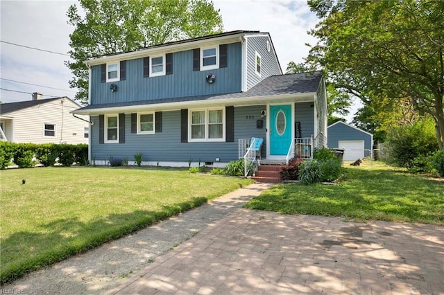 traditional-style house with a detached garage, board and batten siding, and a front yard