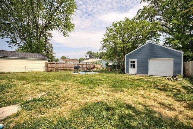 view of yard featuring a fenced backyard, an outbuilding, and a detached garage