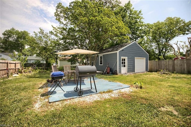 exterior space featuring a fenced backyard, a patio area, a yard, and a detached garage