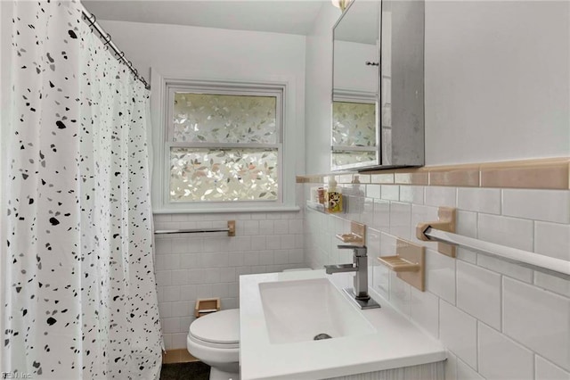bathroom featuring toilet, tile walls, curtained shower, and vanity