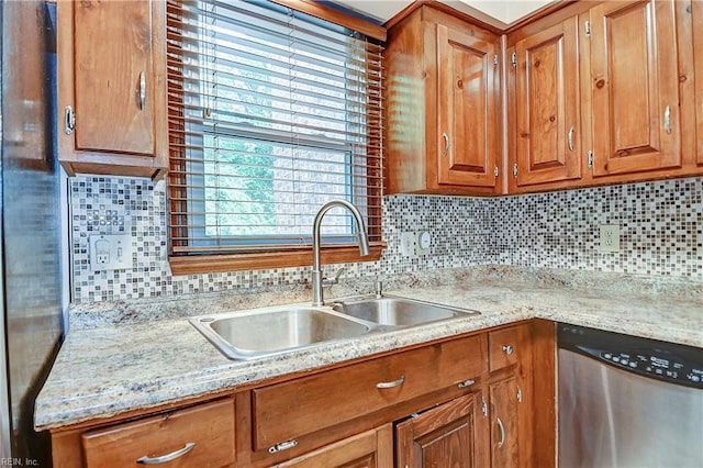 kitchen featuring a sink, brown cabinets, decorative backsplash, and dishwasher