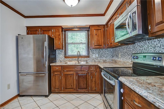 kitchen featuring a sink, tasteful backsplash, ornamental molding, light stone countertops, and appliances with stainless steel finishes
