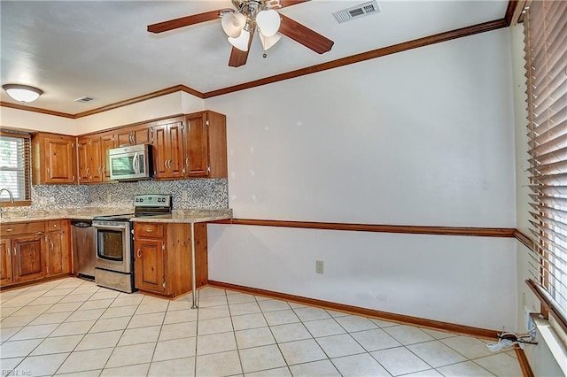 kitchen with appliances with stainless steel finishes, visible vents, brown cabinetry, and decorative backsplash