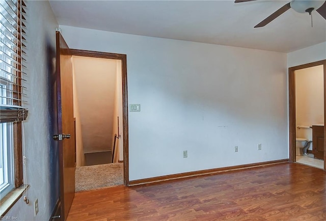 empty room featuring baseboards, ceiling fan, and wood finished floors