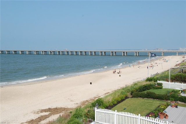 view of water feature featuring fence and a view of the beach