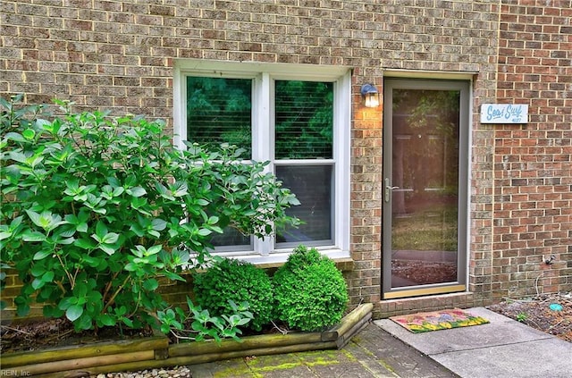 property entrance featuring brick siding