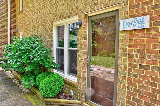 doorway to property with brick siding