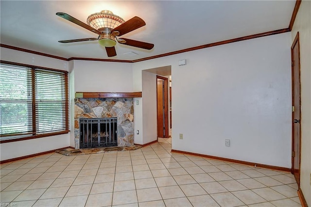 unfurnished living room featuring ornamental molding, ceiling fan, light tile patterned floors, baseboards, and a stone fireplace