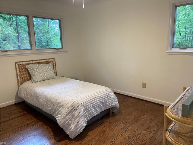 bedroom with baseboards and dark wood-style flooring