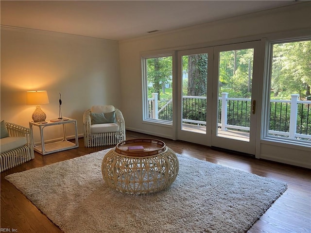 sitting room with ornamental molding, baseboards, and wood finished floors