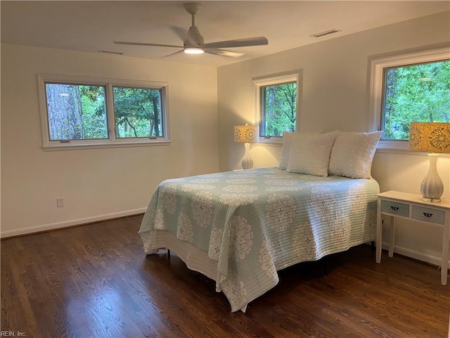 bedroom featuring wood finished floors, visible vents, and multiple windows