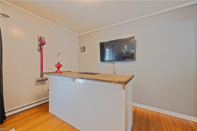 bar with baseboard heating, ornamental molding, light wood-type flooring, and baseboards