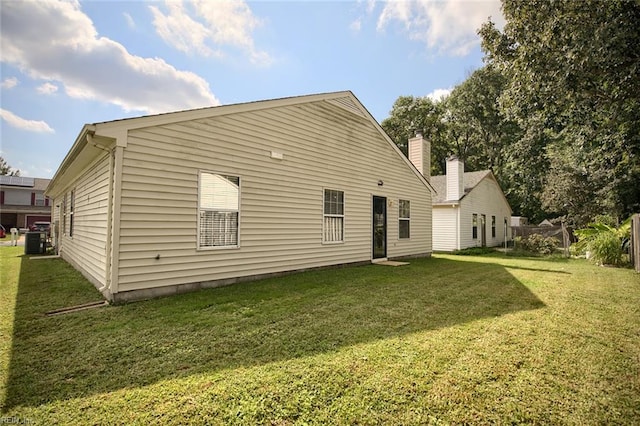 back of property with a lawn and cooling unit