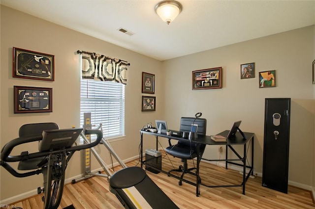 home office featuring visible vents, light wood-style floors, and baseboards