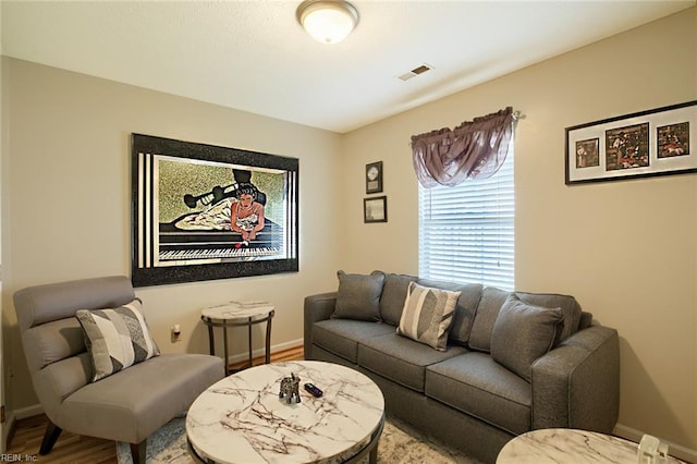 living room with baseboards, wood finished floors, and visible vents