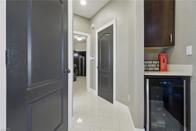 hallway with wine cooler, baseboards, and light tile patterned flooring