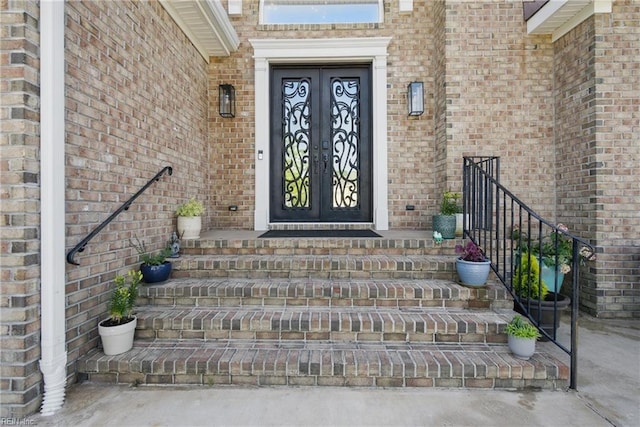 view of exterior entry with brick siding and french doors