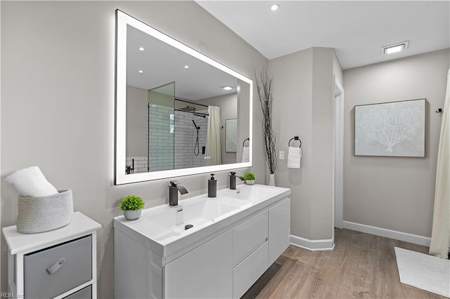 390 Naval Base Rd, Norfolk, VA 23505 - bathroom featuring double vanity, wood finished floors, a sink, baseboards, and a shower stall
