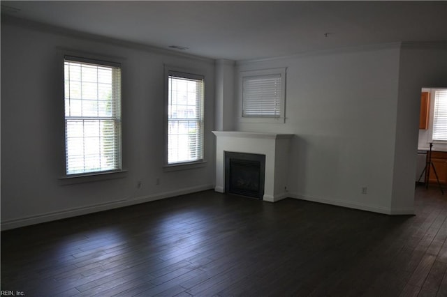 unfurnished living room with baseboards, a fireplace, crown molding, and dark wood-style floors