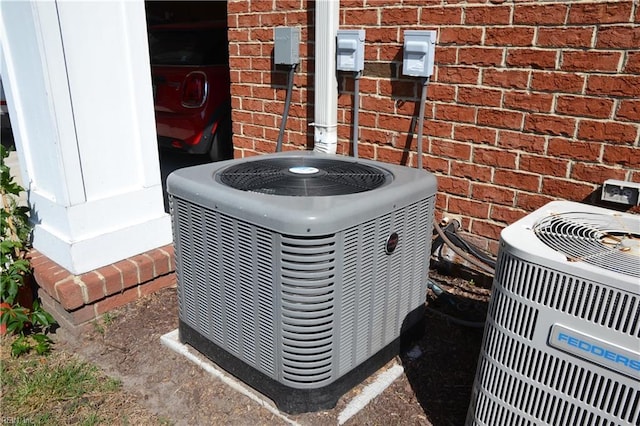 details featuring central AC unit and brick siding