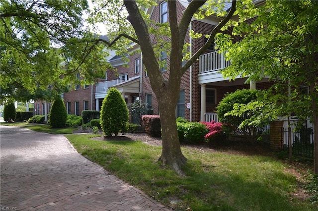view of side of home with brick siding and a balcony