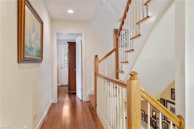 hall with recessed lighting, wood finished floors, baseboards, and stairs