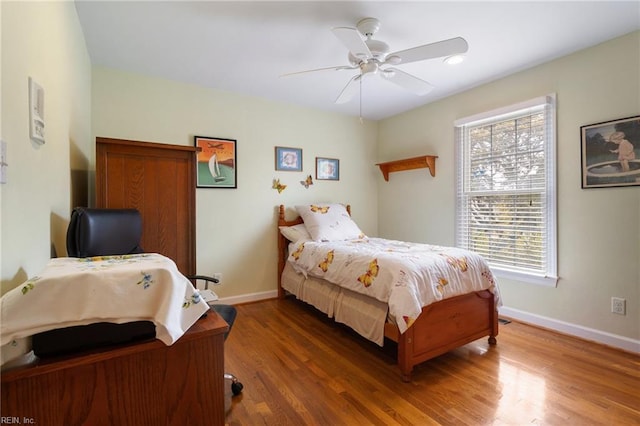 bedroom with baseboards, a ceiling fan, and wood finished floors