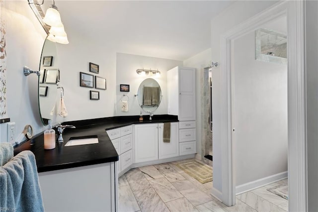 full bath featuring walk in shower, marble finish floor, and vanity