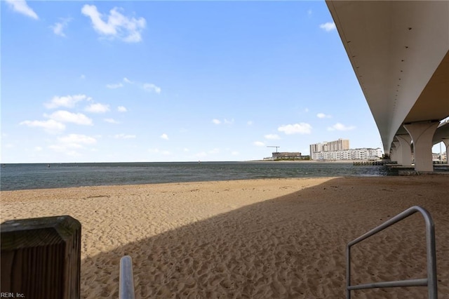 view of yard with a water view and a beach view