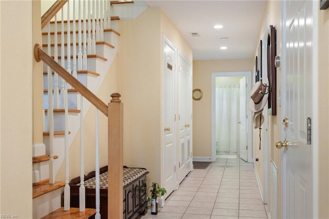 hallway with stairs, visible vents, recessed lighting, light tile patterned floors, and baseboards
