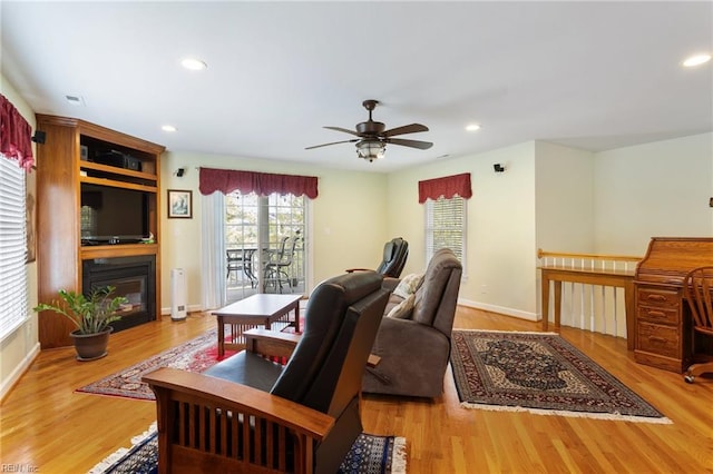 office space with a ceiling fan, recessed lighting, baseboards, wood finished floors, and a fireplace