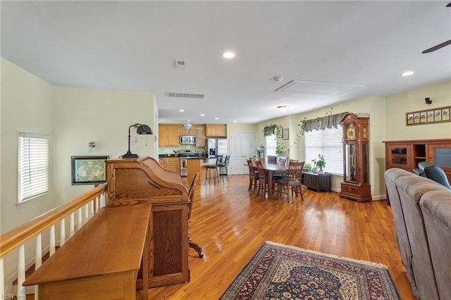 dining room featuring ceiling fan, attic access, light wood-type flooring, and visible vents