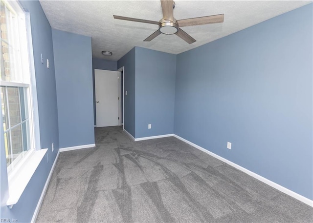 unfurnished room with ceiling fan, a textured ceiling, carpet floors, and baseboards