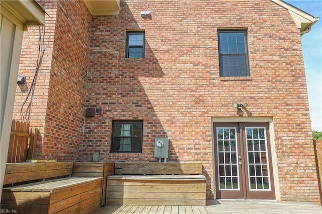 rear view of property featuring brick siding and french doors
